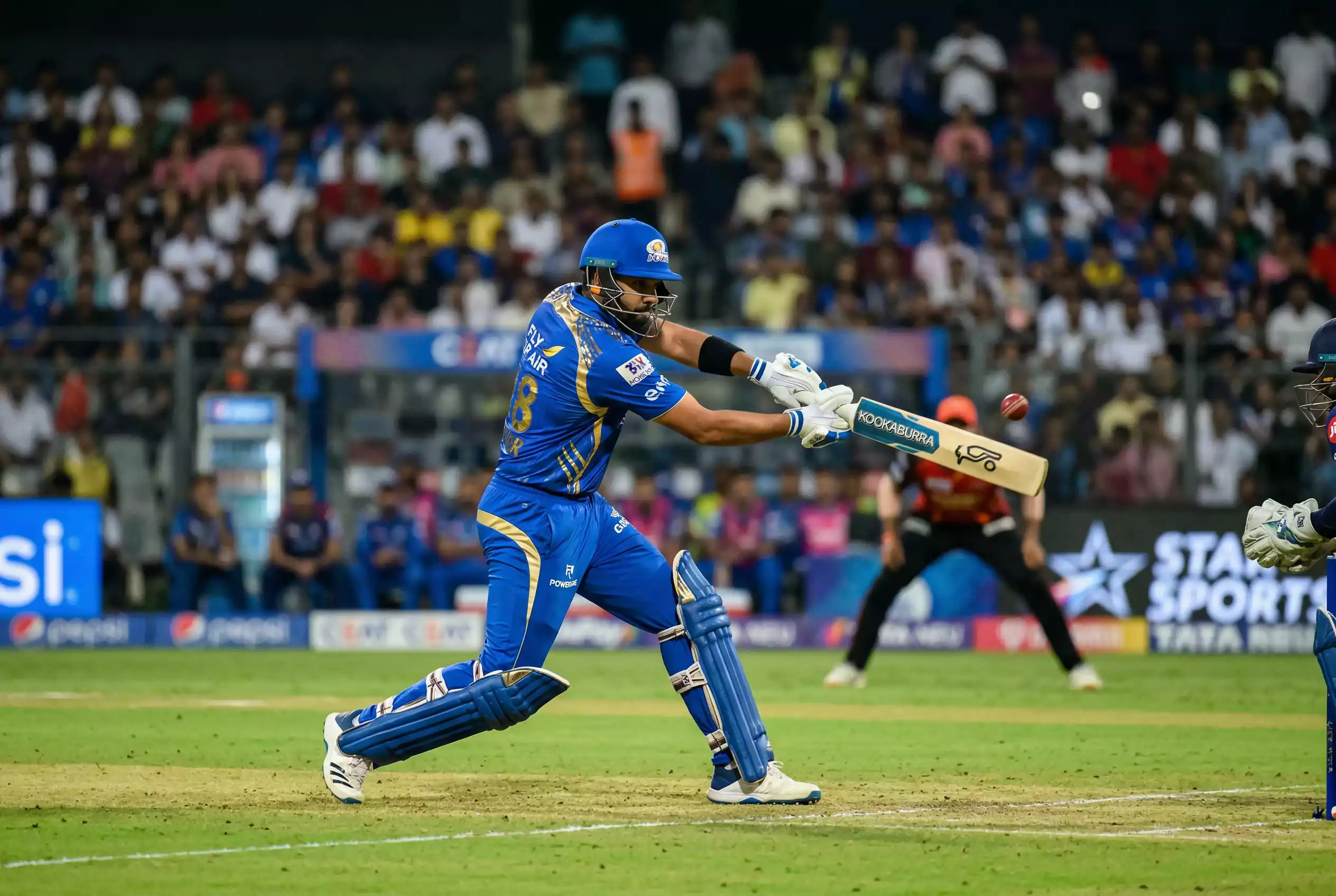 IPL Cricket-Spieler beim Schlag während eines Turniermatches mit Stadionkulisse
